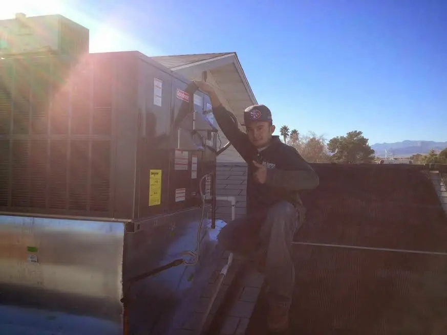 HVAC technician performing HVAC Inspection on a rooftop unit in Worcester